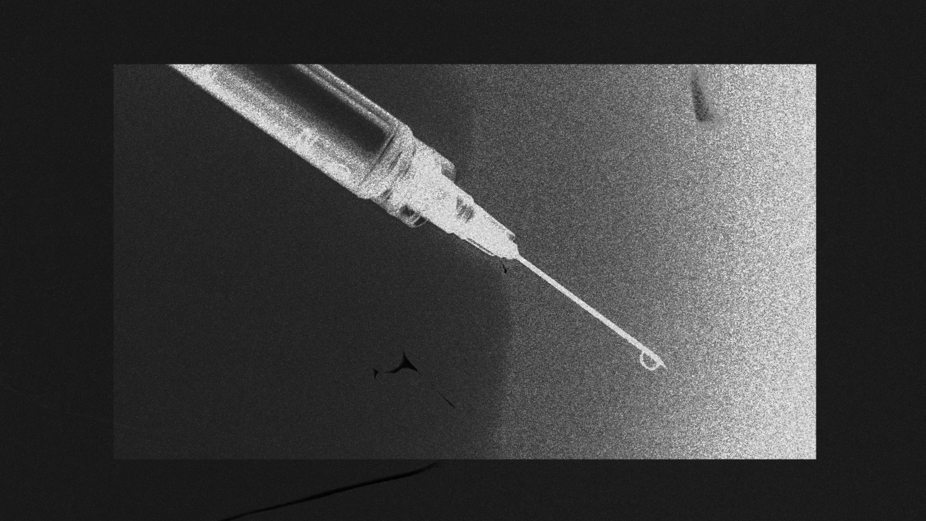 A moody black and white photo of a syringe.